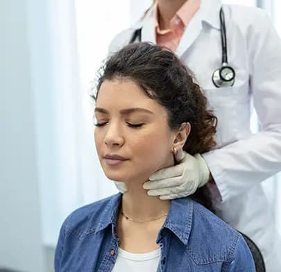 Doctor performing neck palpation during head and neck surgery examination.